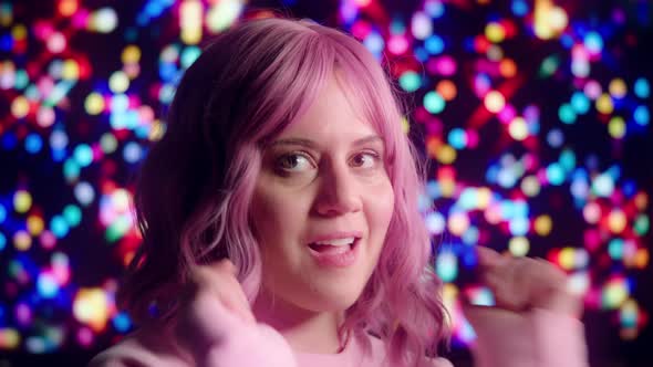 Pink-Haired Party Girl Dancing with Colorful Lights in Background alt