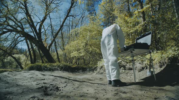 The Scientist in a Chemical Protective Suit Examines the Samples in the Contaminated Area. Biohazard