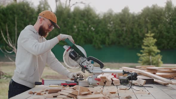 Close Up Shot of Man Cutting Wood Using Table Saw on Construction Site alt