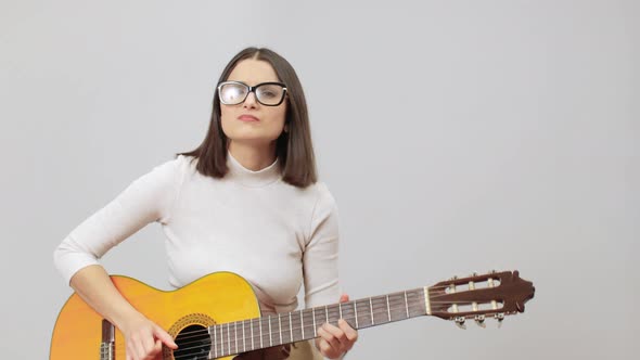 Woman In Beige Outfit Playing Solo With Bends On Her Acoustic Nylon Strings Guitar