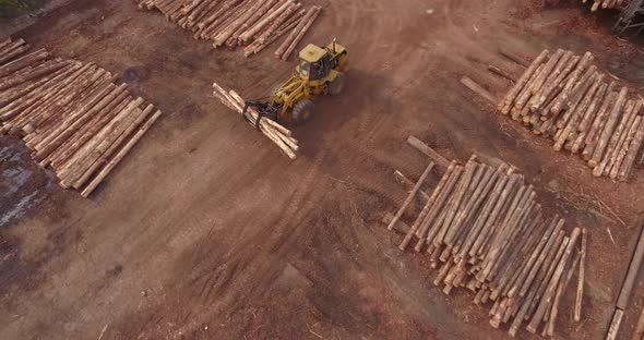 4K Aerial Shot Descending Towards and tracking Timber Logging Front loader Vehicle alt