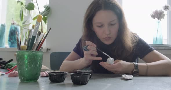 Woman Making Doll Ceramic Part. Female Sitting and Creating Ear for Doll at Home at Table. Pottery alt