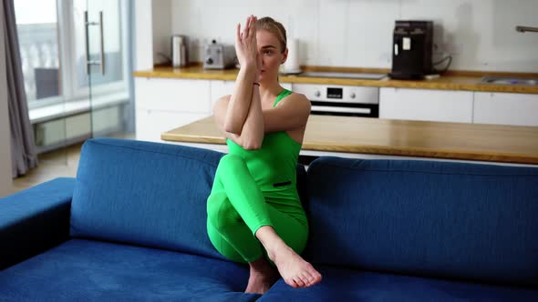 Young Woman Practicing Eagle Pose at Home on the Couch alt