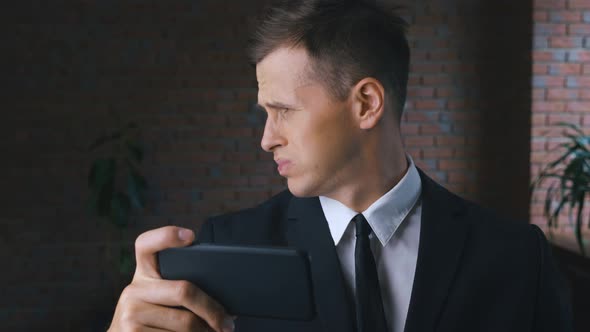 Young Man is Watching an Unpleasant Video on a Smartphone