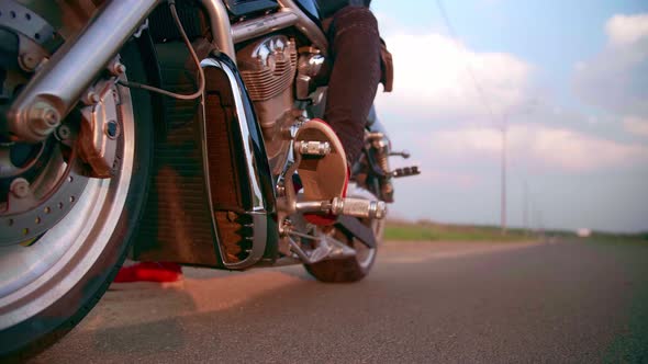 The Biker Turns on the Gear on the Motorcycle Chopper and Starts to Ride