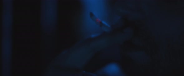 Close up of a man smoking a cigarette outside at night, dealing with anxiety and post trauma alt