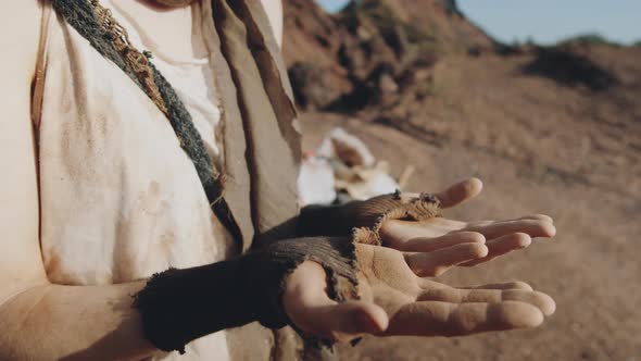 Dystopian Woman Looking at Dusty Hands alt