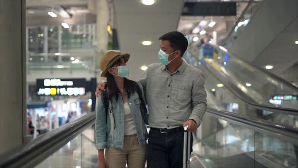 Couple Asian people walking in airport terminal waiting for  flight boarding