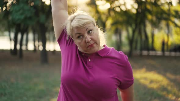 Fat Woman Do Exercises at the Park alt