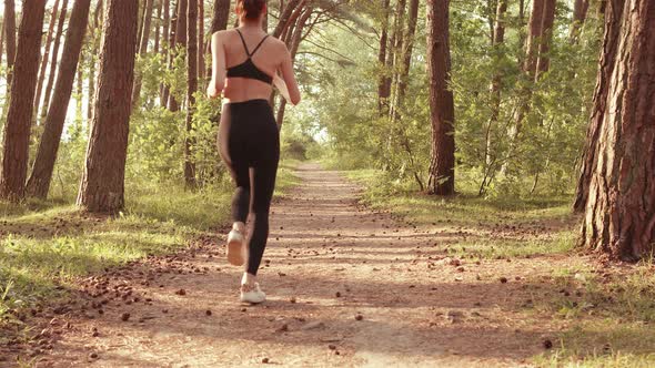 Sportswoman Running Along the Trail