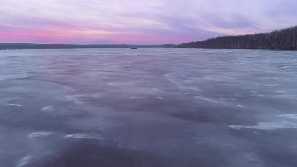 Flight Above the Frozen Lake at the Dusk with the Red Sunset on the Background alt