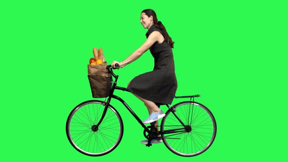 Beautiful Woman Riding a Bicycle Over a Green Screen, Looking Upwards Impressed alt