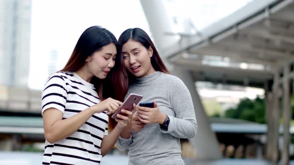 Two Teenager travellers checking location map on smartphone 