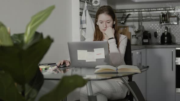 Contemporary Girl Browsing Laptop And Talking With Wireless Earphones alt