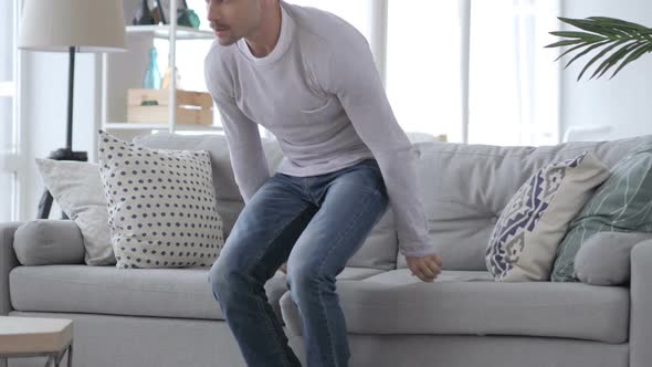 Adult Man Sitting on Couch Leaving the Room alt