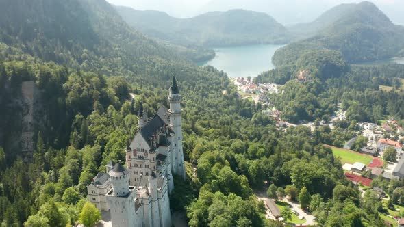 Aerial Footage of Neuschwanstein Castle Next To Lake Alpsee Bavaria Germany alt