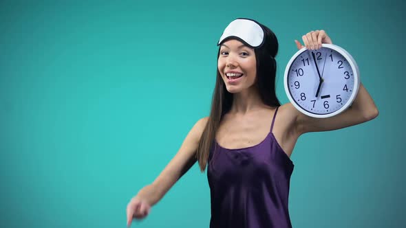 Energy Woman in Pajamas Pointing at 7 Am Clock, Wake Up Early, Healthy Lifestyle alt
