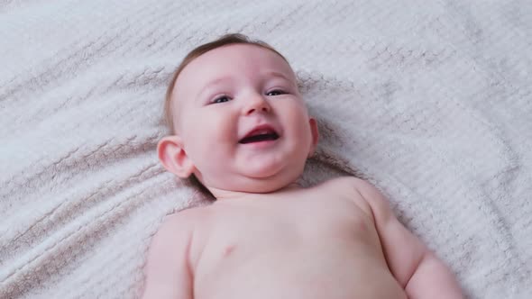 Portrait of a happy infant baby on a bed in a home living room, aged from eight months