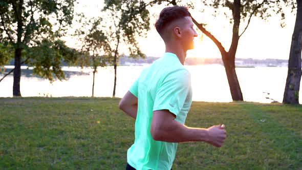 Happy Athletic Man Running at Sunrise River Outdoor Morning Marathon alt