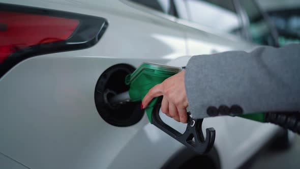 Woman Fills Petrol Into Her Car at a Gas Station Closeup alt