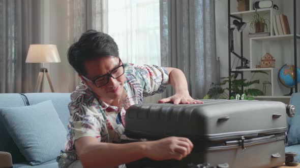 Man Packing His Clothes And Closing His Suitcase In The Living Room He Preparing For Vacation Trip alt