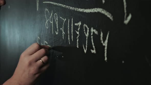 Man Writes Math Formula on Blackboard