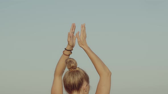 Blond Young Caucasian Girl Practicing Yoga on a Cliff in Front of the Sea or Ocean