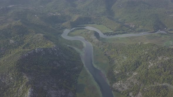 Aerial view of Rijeka Crnojevica. River bends around the mountain, scenic valley hills, Montenegro