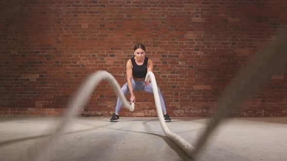 Active Fit Female Athlet Is Doing Battle Rope. Slow Motion alt