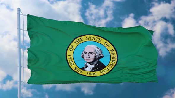 Washington State Flag on a Flagpole Waving in the Wind Blue Sky Background alt
