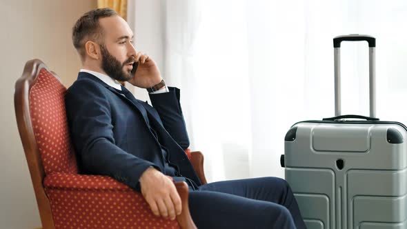 Confident Stylish Male Businessman Discussing Problem Talking Using Smartphone at Hotel Room alt