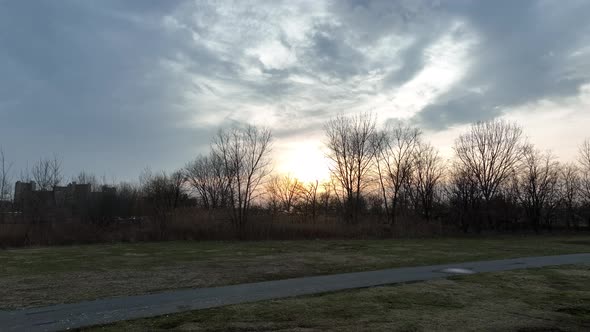 A low angle shot of Calvert Vaux Park in Brooklyn, NY during a cloudy sunset. The drone camera dolly alt