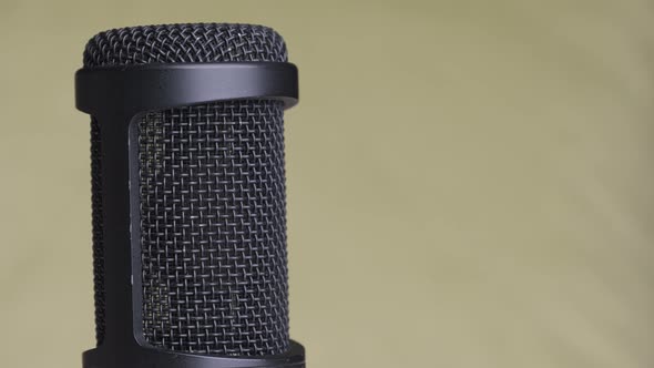 Studio Condenser Microphone Rotates on Yellow Background with Place for Text alt