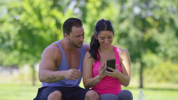 Athletic couple at park take selfies together