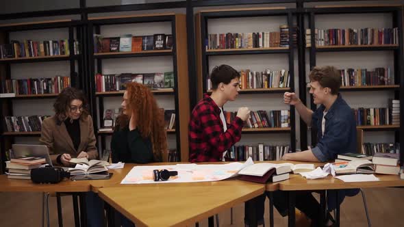 Slow Motion of Students Making Fun After Hours of Studying in Uni Library alt