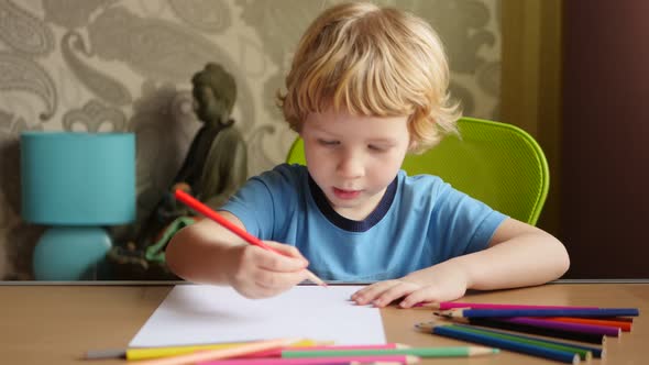 4-Year Blonde Boy Drawing With Colored Pencils.