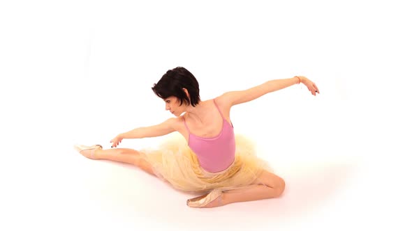 Young Ballerina Spinning and Making Dance Trick Known As Battements Tendus, in the Studio on a White
