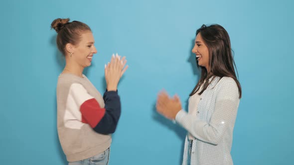 Two Carefree Young Girls Going Crazy. Women in hipster summer clothes playing pat-a-cake alt
