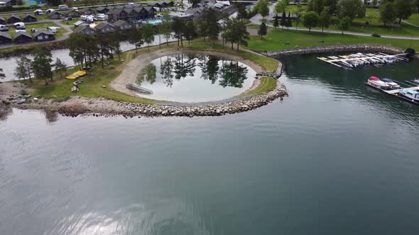 Unique artificial circular pond for swimming in Kinsarvik Norway - Aerial with tilt-down and mirror- alt