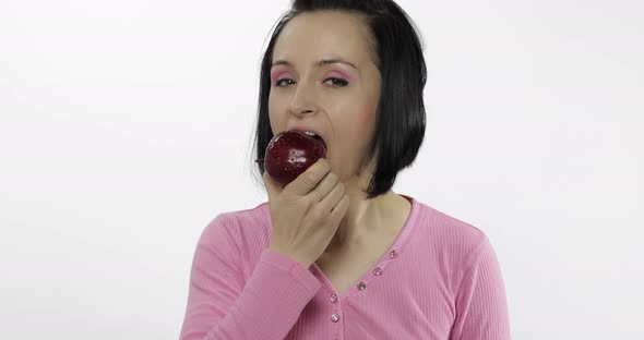 Young Woman Eating Apple and Says Yum. Girl Takes First Bite and Say Wanna Bite alt