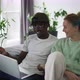 Happy Biracial Couple Sitting on Sofa with Laptop Congratulating Each Other - VideoHive Item for Sale
