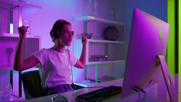 Beautiful Gamer Winning Esport Competition Online in Neon Lights at Home Closeup alt