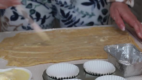A Woman Butters A Rolled Out Dough. Prepares Cruffin With Raisins And Candied Fruit alt