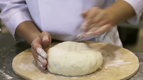 Cook, Baker or Pastry Chef Rolls Dough for Pizza