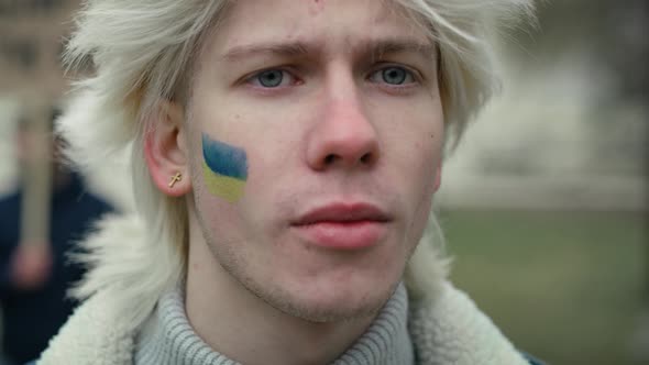 Close up portrait of young caucasian man with Ukrainian flag painted on his cheek. Shot with RED hel alt