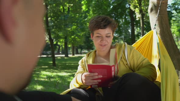 Girl in a hammock reading out loud alt