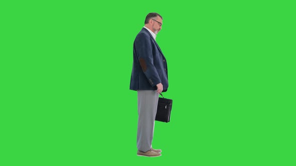Mature Business Man Consulting His Watch on a Green Screen Chroma Key alt