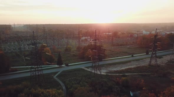 view of the structure of high-voltage lines outside the city at sunset. Camera motion back. alt