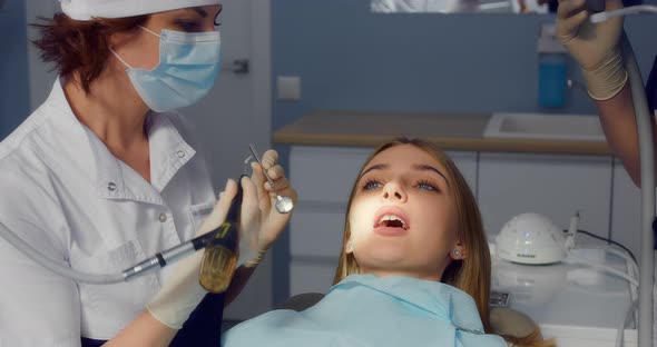 Dentist Performs Professional Teeth Cleaning for a Beautiful Female Patient alt