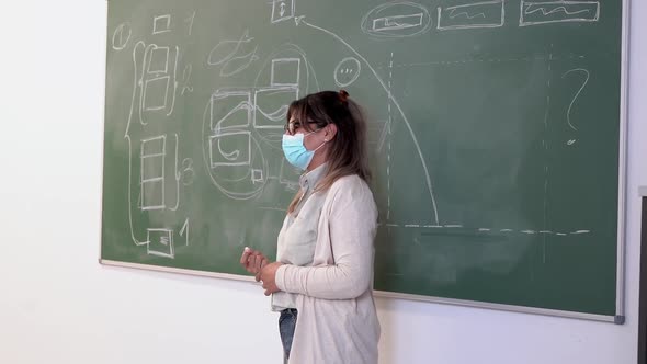 Mature teacher wearing safety face mask during class inside university